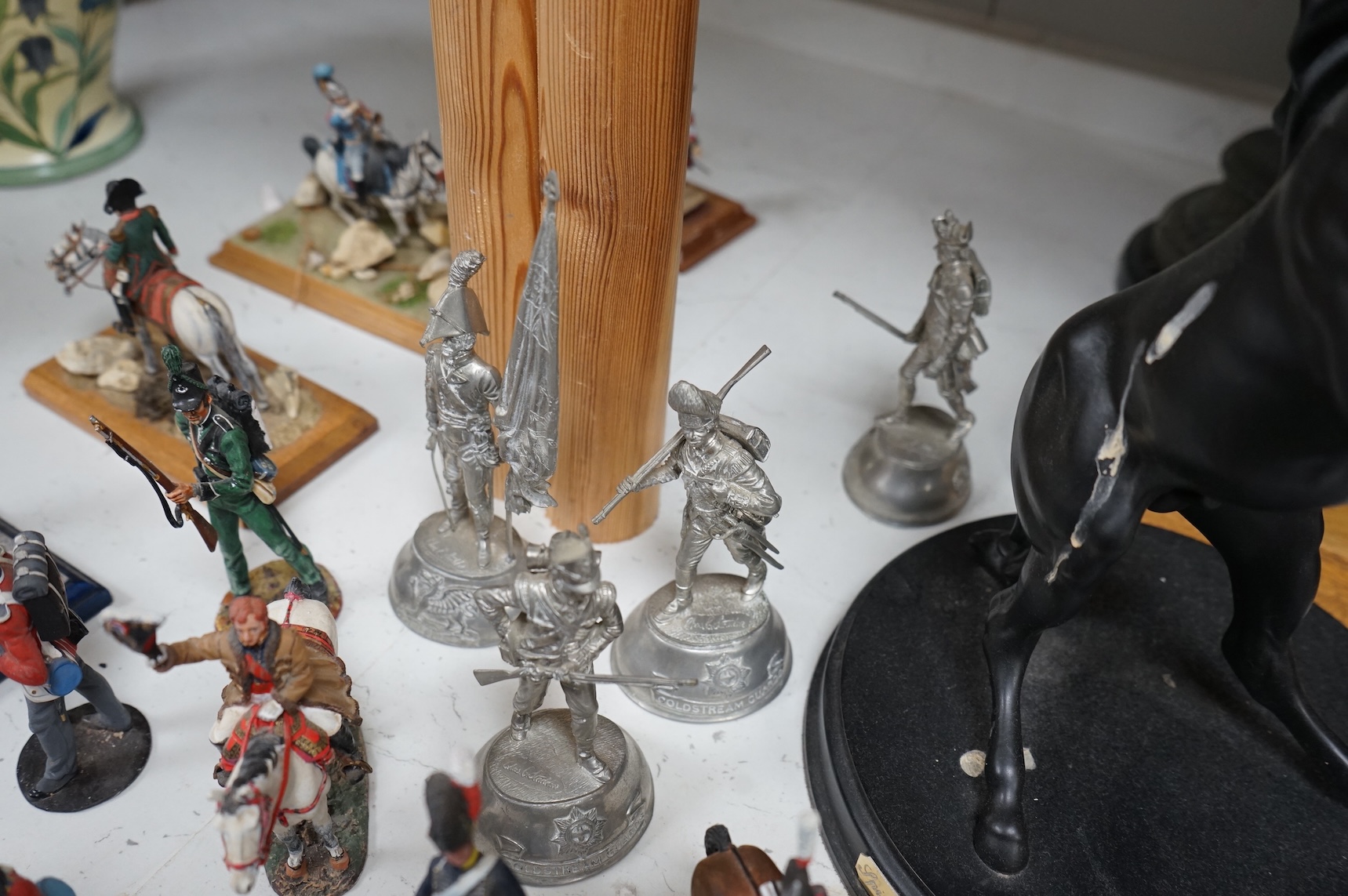 A pair of spelter figures a brass door stop two models of horses two other figures and a large group of toy soldiers. Tallest 45cm.